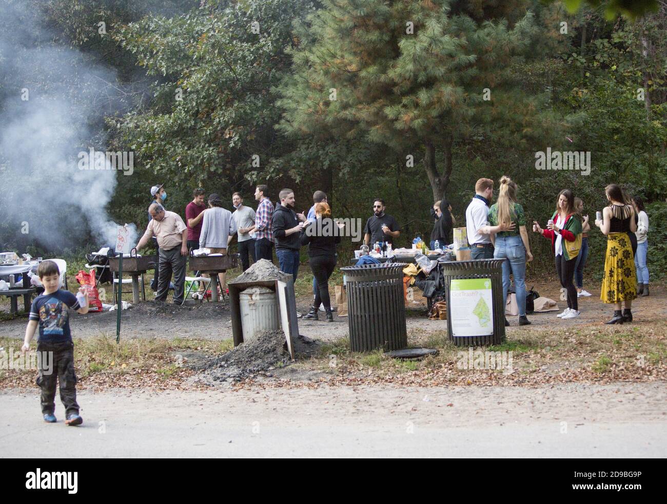 People enjoy themselves at a barbecue party in Prospect Park feeling free and mainly maskless although it is the time of Covid-19 in autumn 2020. Stock Photo