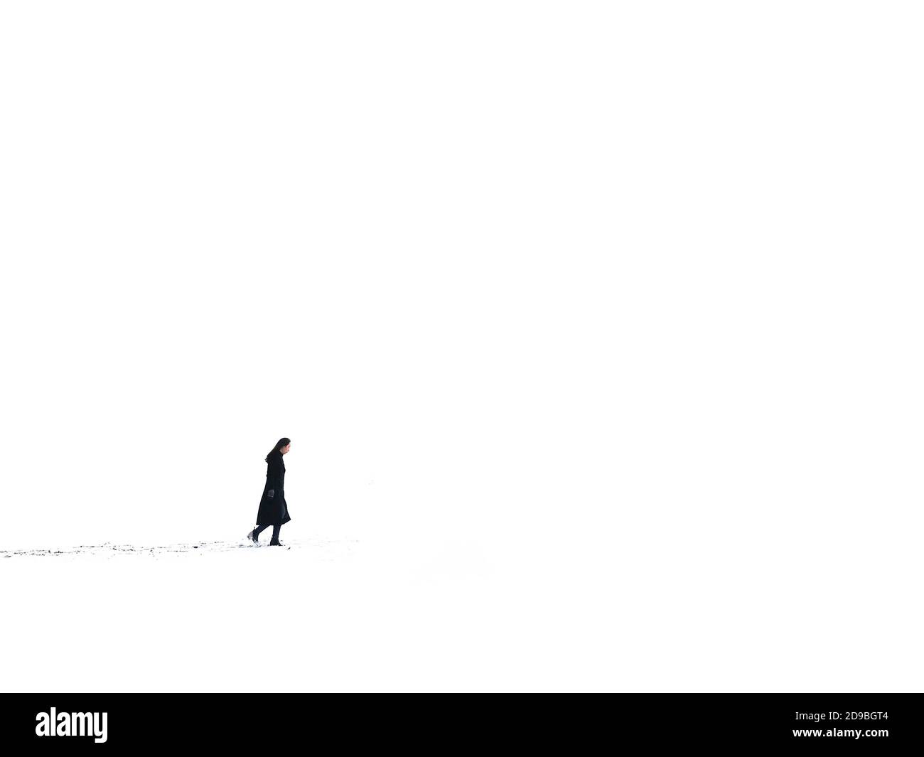 Side view of a woman walking in the snow, South Korea Stock Photo