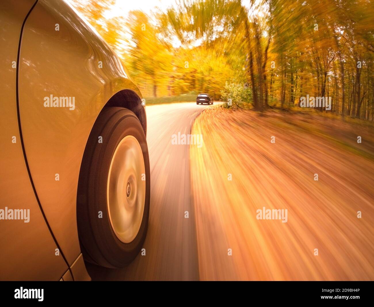 Car speeding along a road in autumn, USA Stock Photo