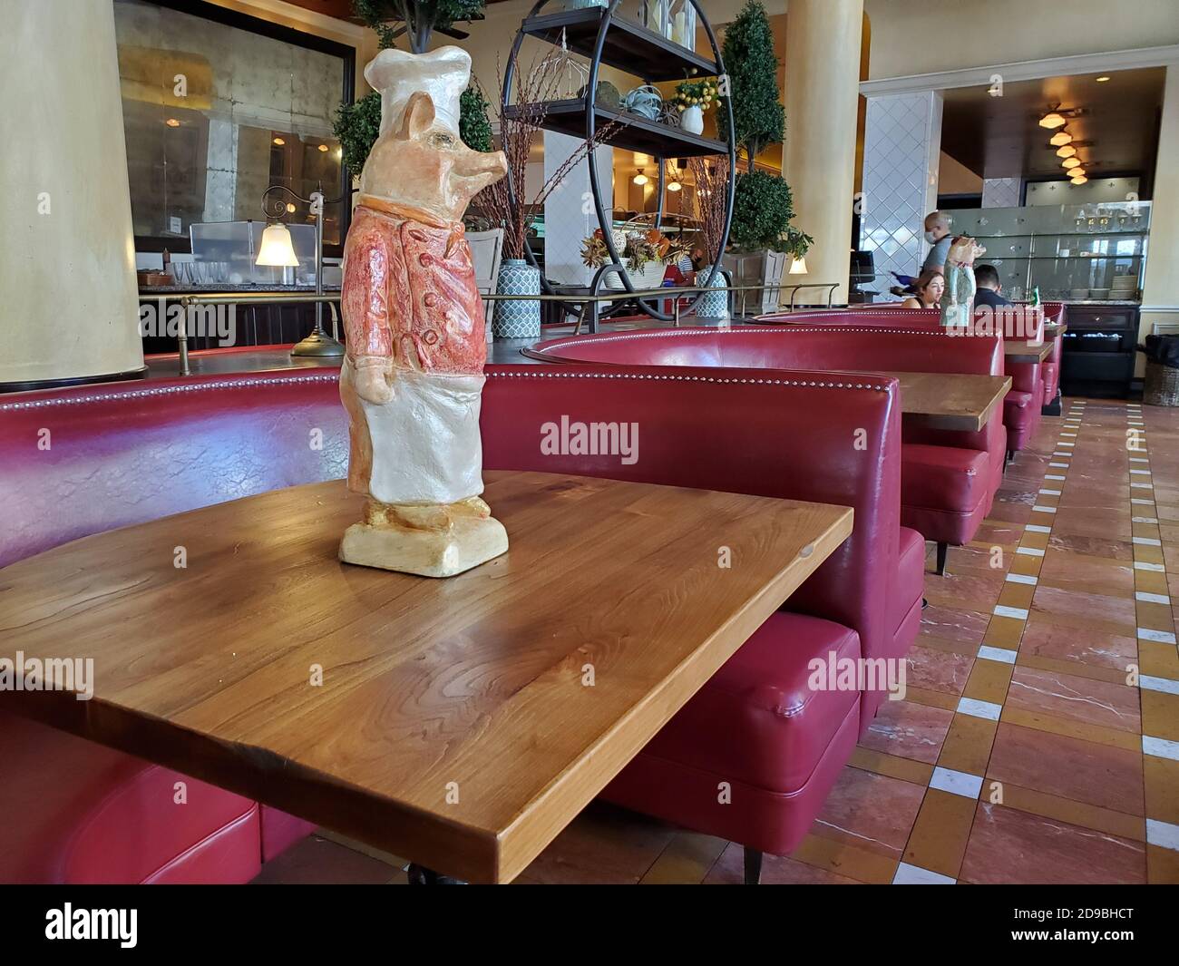 At a restaurant in San Jose, California, a ceramic pig statue is being used to block off tables to comply with social distancing requirements during Covid-19 coronavirus, October 18, 2020. () Stock Photo