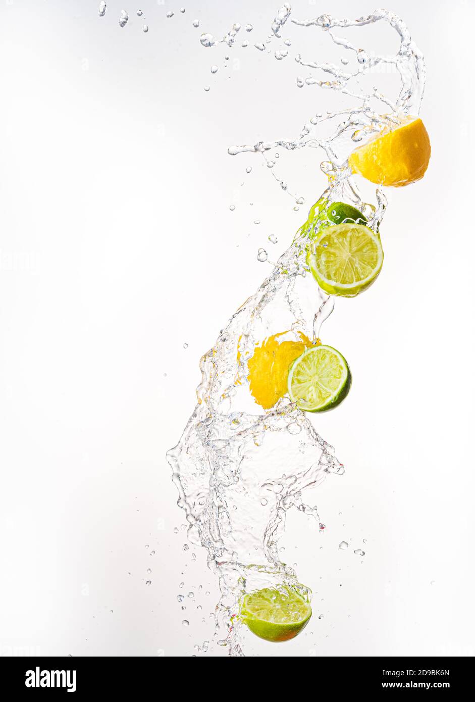 Fresh limes and lemons with water splash in midair, isolated on white background Stock Photo
