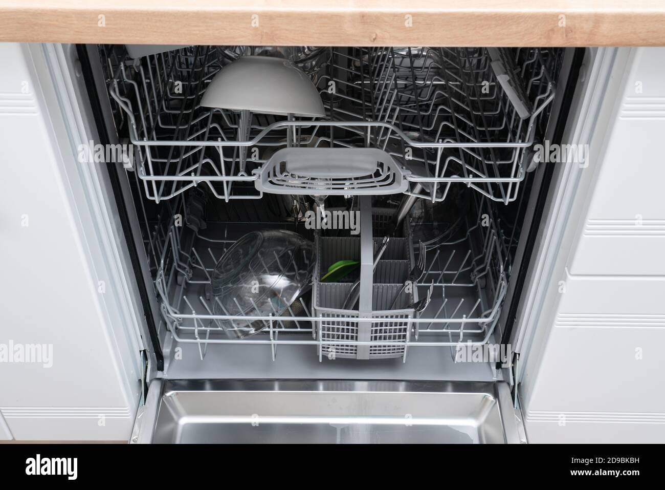 Dishwasher with open door as housework convenient appliance clean utensils cutlery and dishes as