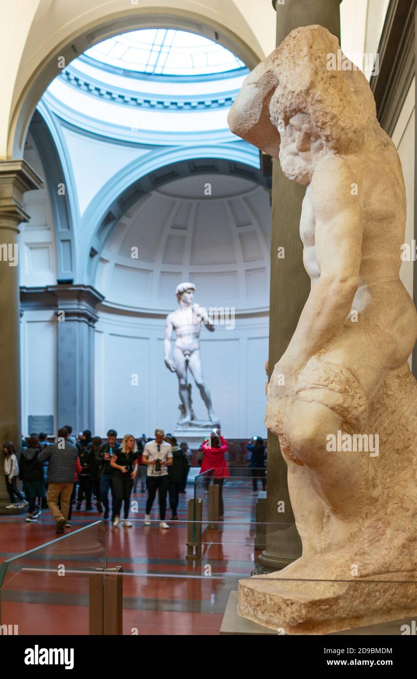 Florence, Italy - February 14, 2019: Accademia Gallery, sculptures unfinisced I Prigioni and sculpture of David in the background, by Michelangelo Stock Photo
