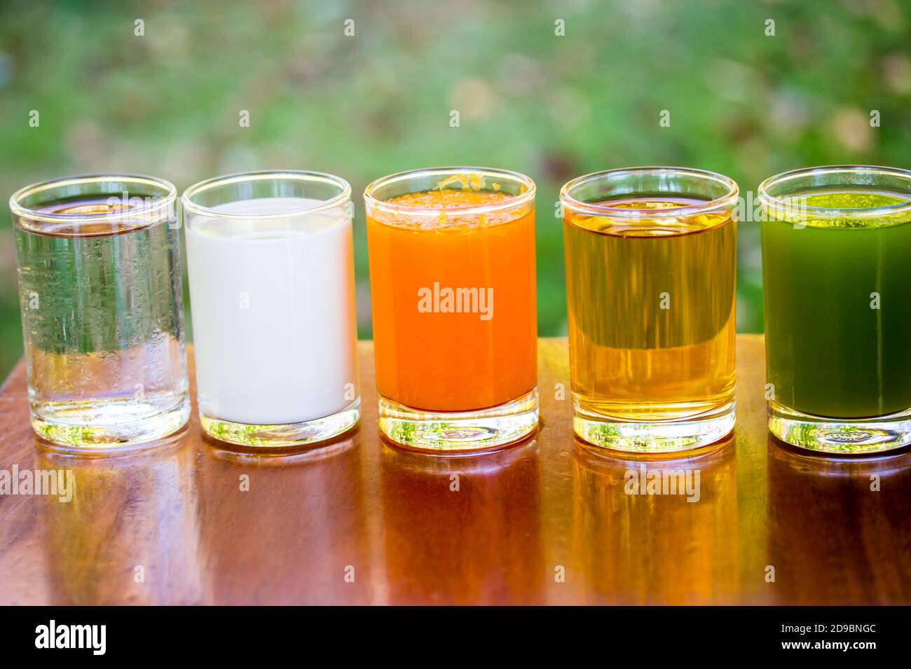 Fruit juices, orange juice, apple juice, kiwifruit juice,with milk and water in glass on the table. Stock Photo