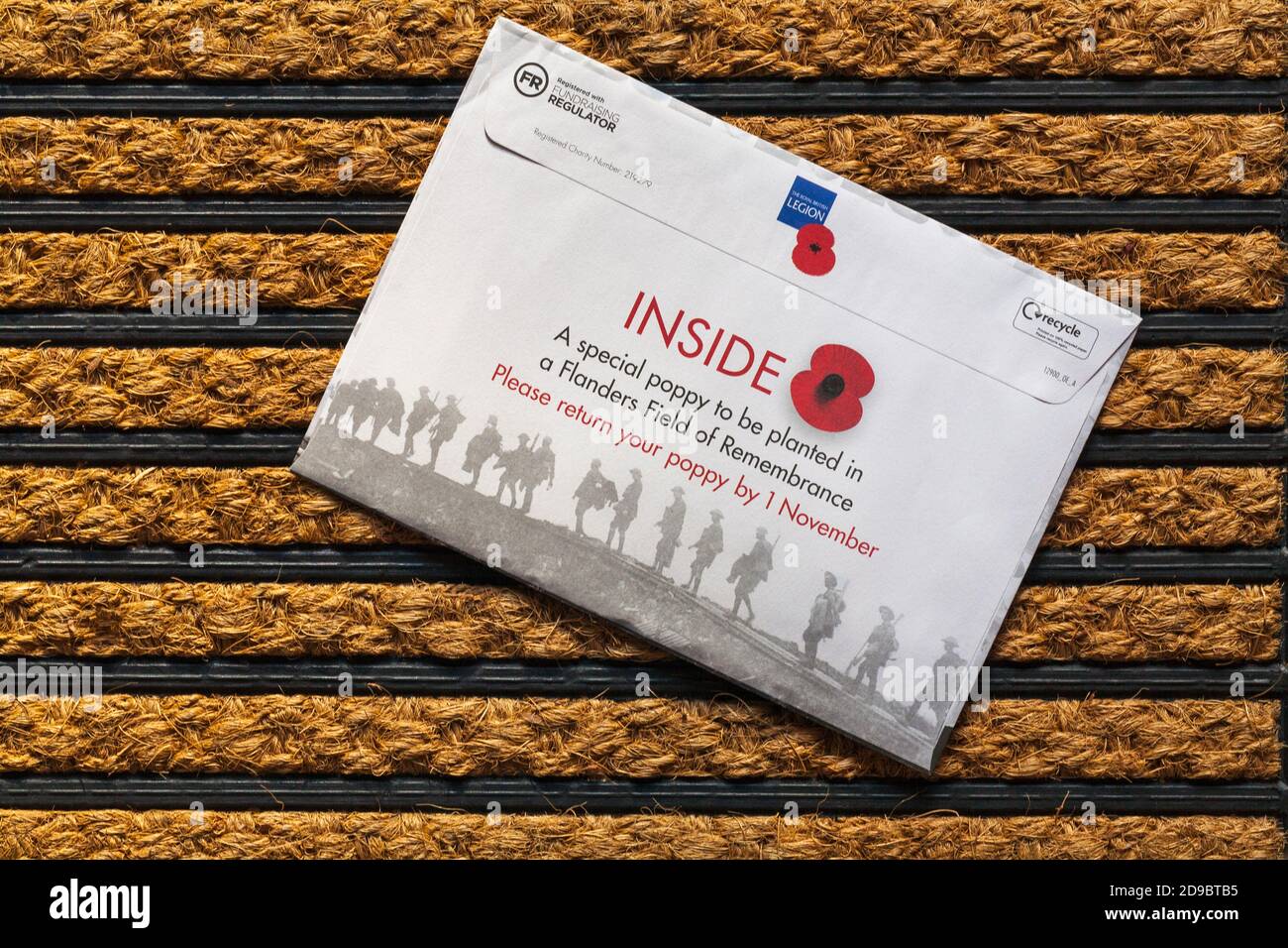 Post mail on doormat - charity appeal, the Royal British Legion inside a special poppy to be planted in a Flanders Field of Remembrance Stock Photo