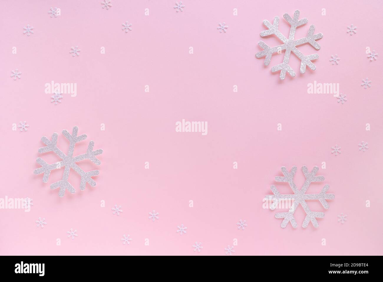 Christmas composition. Christmas frame made of snowflakes on pastel pink background. Christmas or New Year 2021 minimal concept. Flat lay, copy space Stock Photo