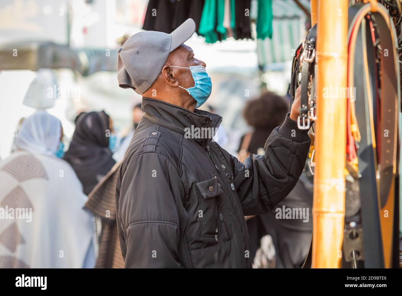 London, UK - 3 November, 2020 - A black man wearing a face mask while shopping at Walthamstow market Stock Photo