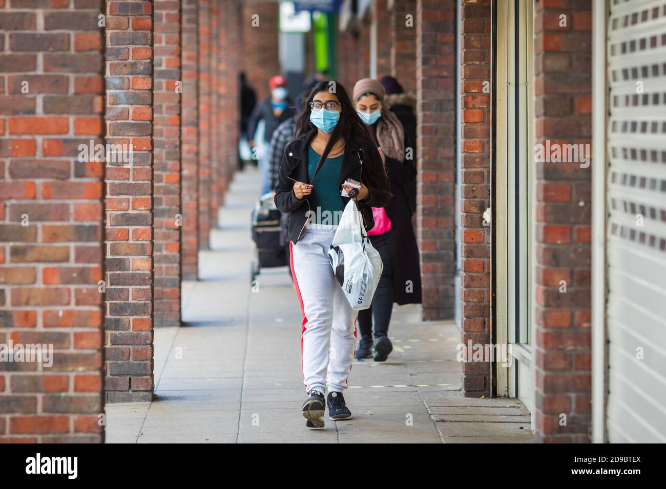 London, UK - 3 November, 2020 - A young woman wearing a face mask while shopping at Walthamstow market Stock Photo