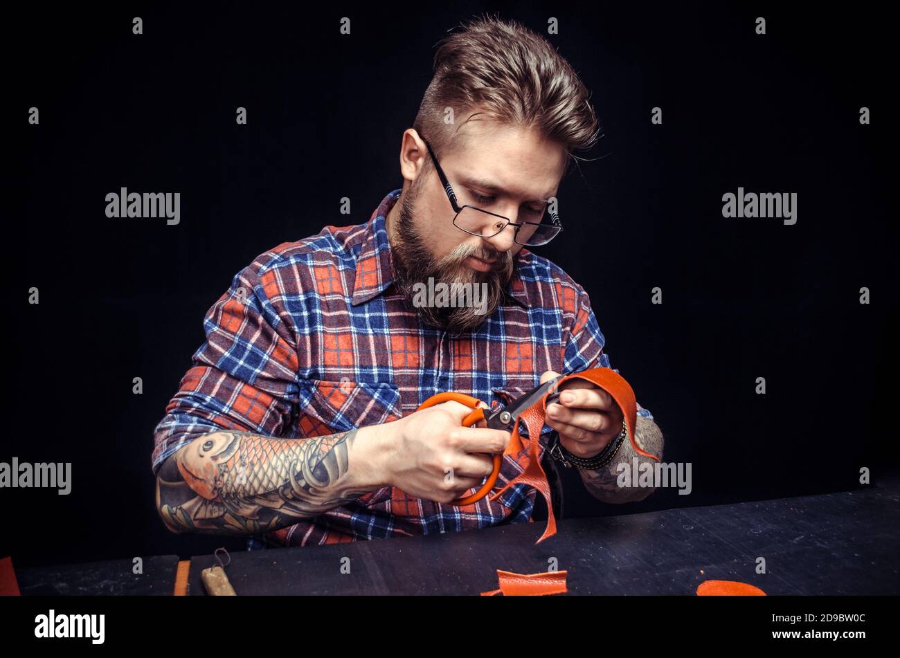 Craftsman forms new leather product in his work area Stock Photo