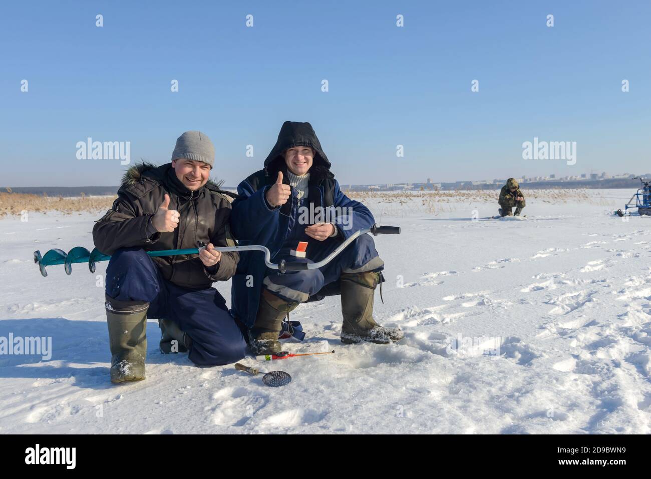 Winter fishing. A fishermans holds an ice drill. Ice fishing. Fishermans, close-up, fishing on the ice. Russia. Stock Photo