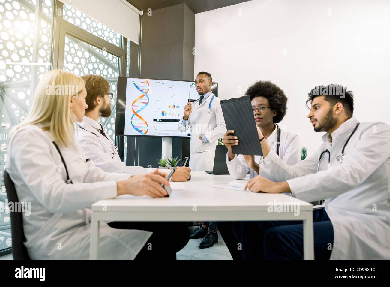 Multiethnic five doctors having a discussion during the meeting at