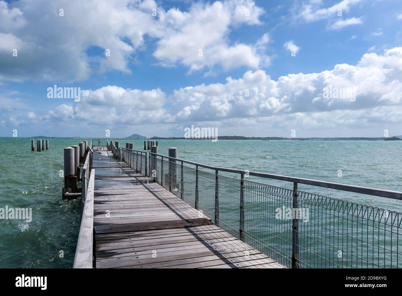 Chek Jawa Broadwalk old wooden floating jetty extends towards azure sea on Pulau Ubin Island, Singapore. Stock Photo