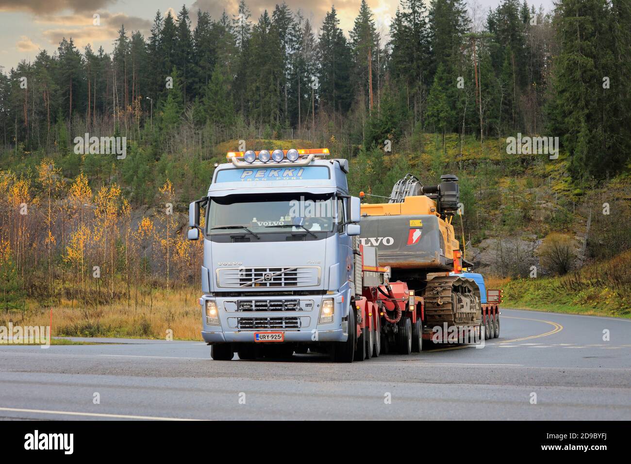 Blue Volvo FH semi trailer Pekki Transport with oversize load transport of Volvo EC700CL crawler excavator. Forssa, Finland. Oct 30, 2020. Stock Photo