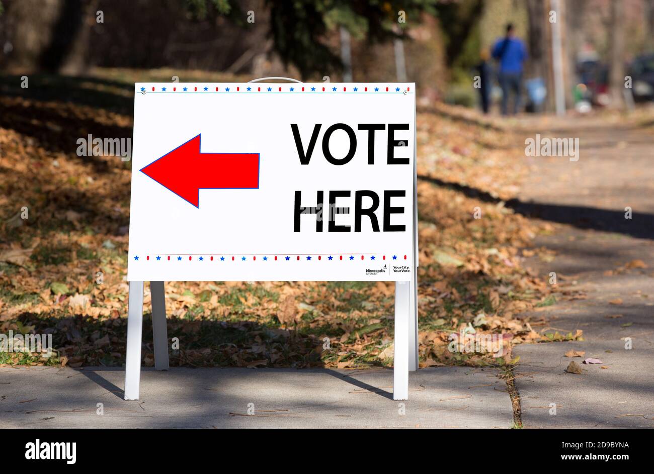 A 2020 Minneapolis election sign with a red directional arrow pointing to a neighborhood polling place during the presidential election Stock Photo