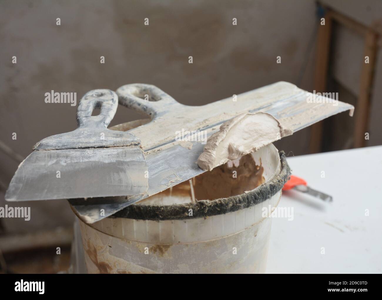 A close-up on two taping knives or joint knives, working tool of a builder used to spread joint compound, mud, final coats over drywalls. Stock Photo