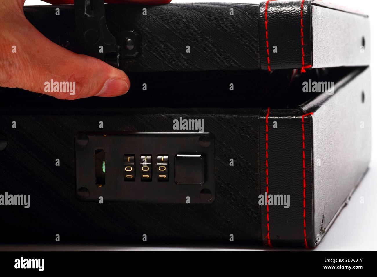 Mans hand opening a briefcase after inputing the code for the