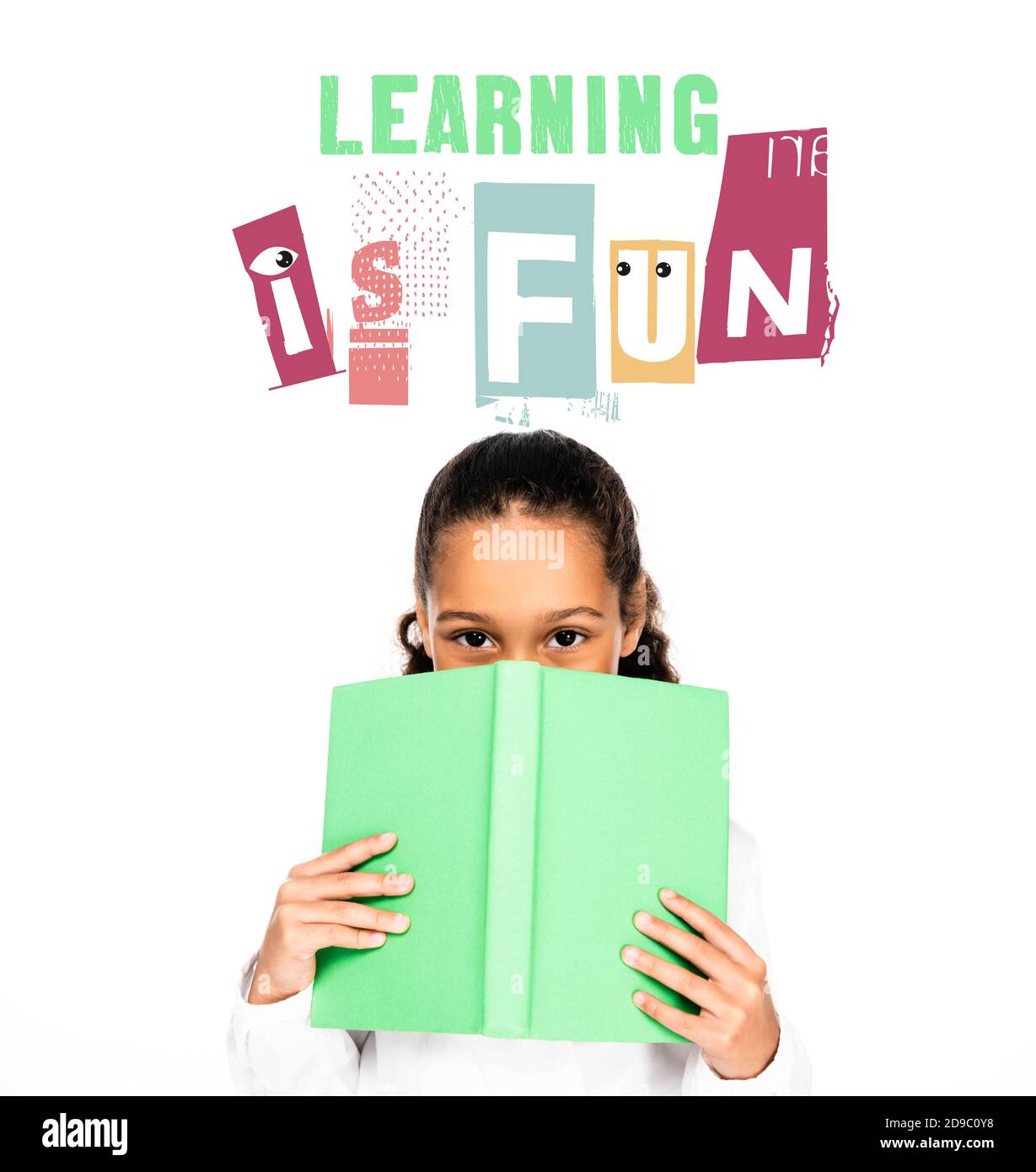 african american schoolgirl looking at camera while holding book near face isolated on white, learning is fun illustration Stock Photo