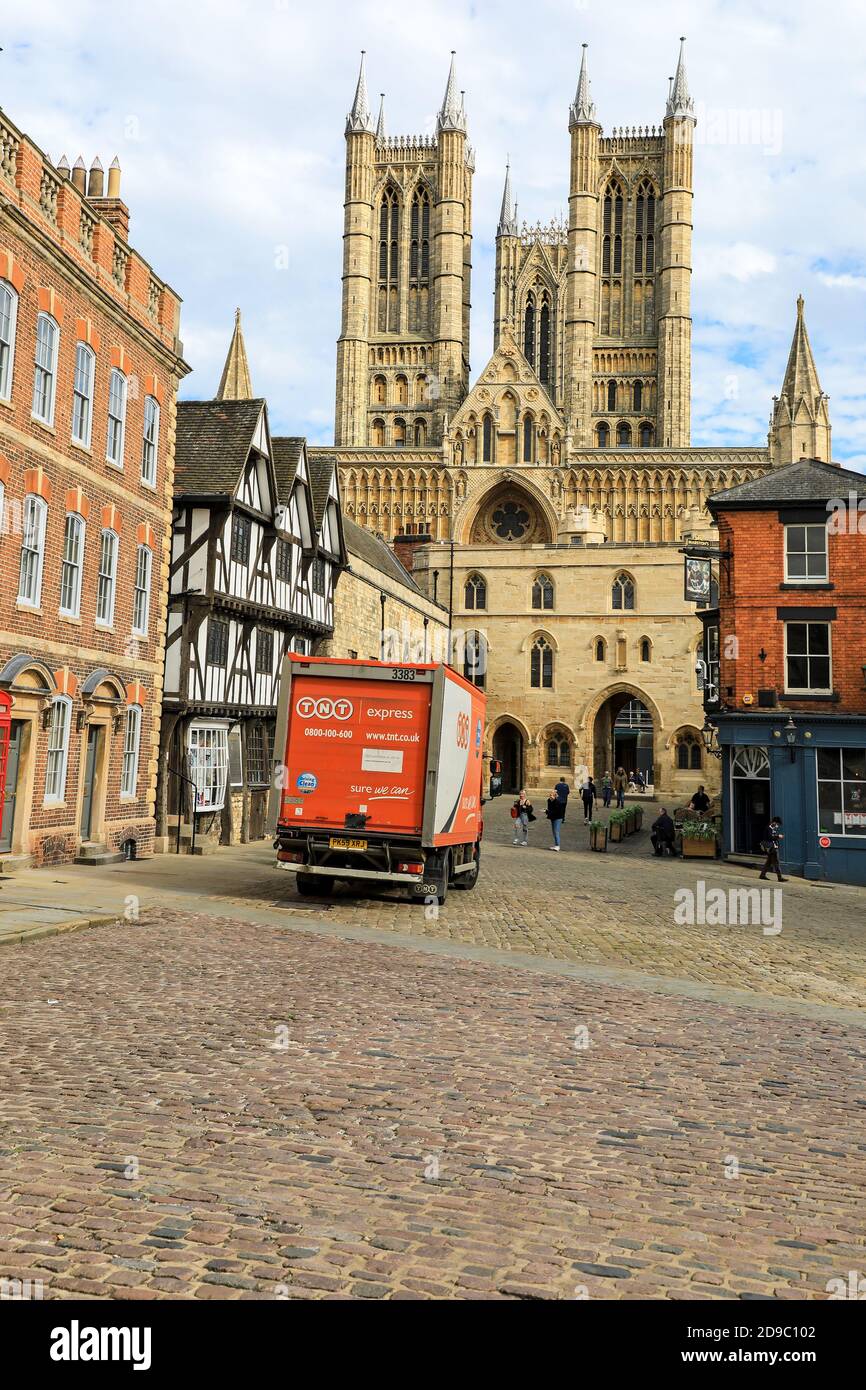 A TNT delivery van or lorry or truck parked on Castle Hill in front of the Exchequer Gate and Lincoln Cathedral, City of Lincoln, England, UK Stock Photo
