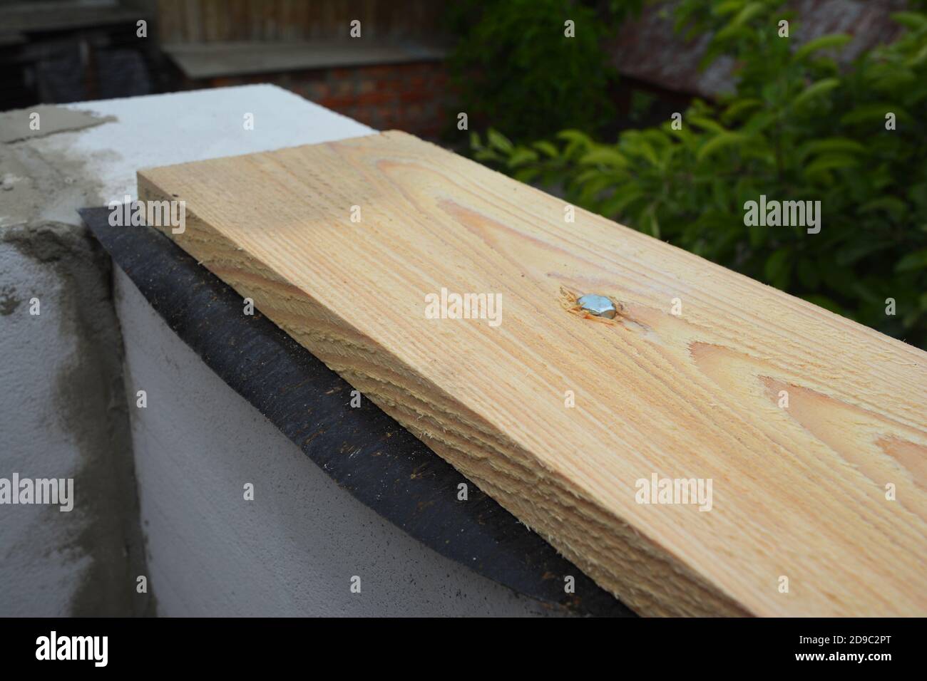 Attaching, fastening a wooden board to concrete wall using concrete screws  or hammer set anchors Stock Photo - Alamy