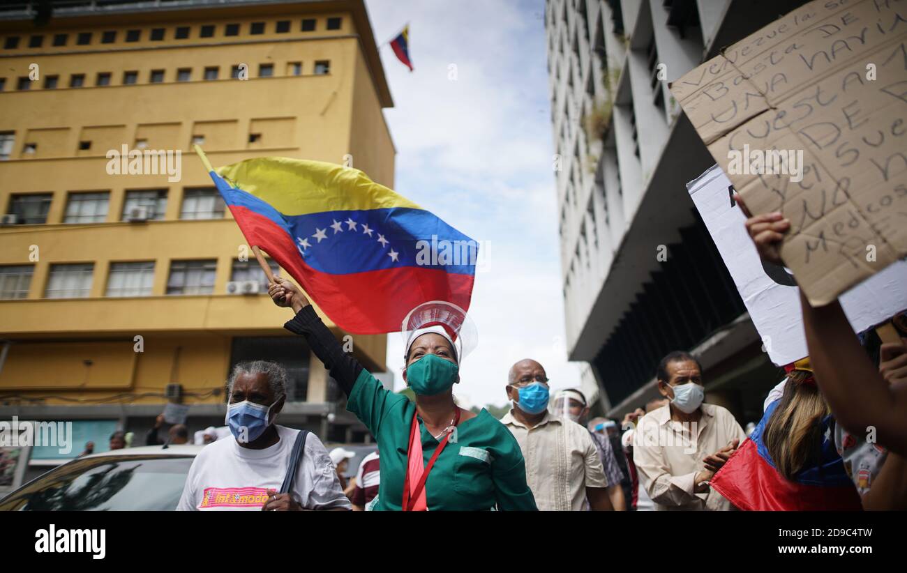 Caracas, Venezuela. 04th Nov, 2020. A health worker waves a flag of Venezuela and shouts slogans during a protest in the middle of the Corona pandemic. A union alliance had called for the protest for better salaries. According to official figures, 93,100 people in Venezuela have fallen ill with Covid-19 and 810 people have died of it. Government loyal media assure that 94 percent of corona virus patients will recover. According to these figures, the mortality rate is lower than in Switzerland. Credit: Rafael Hernandez/dpa/Alamy Live News Stock Photo