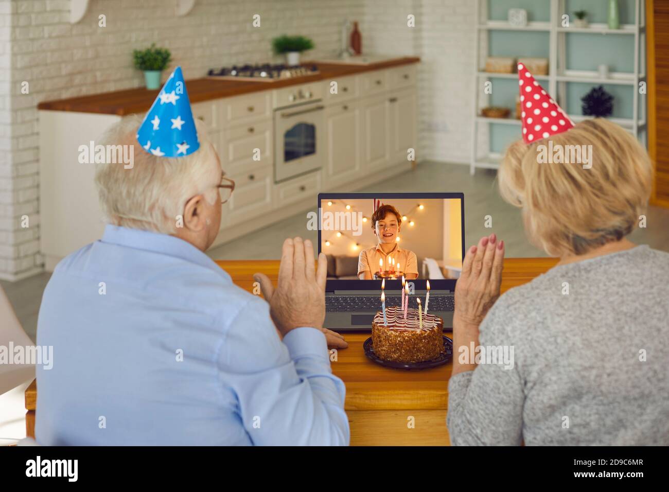 Elderly old couple use a modern laptop to congratulate their grandson on his birthday. Stock Photo
