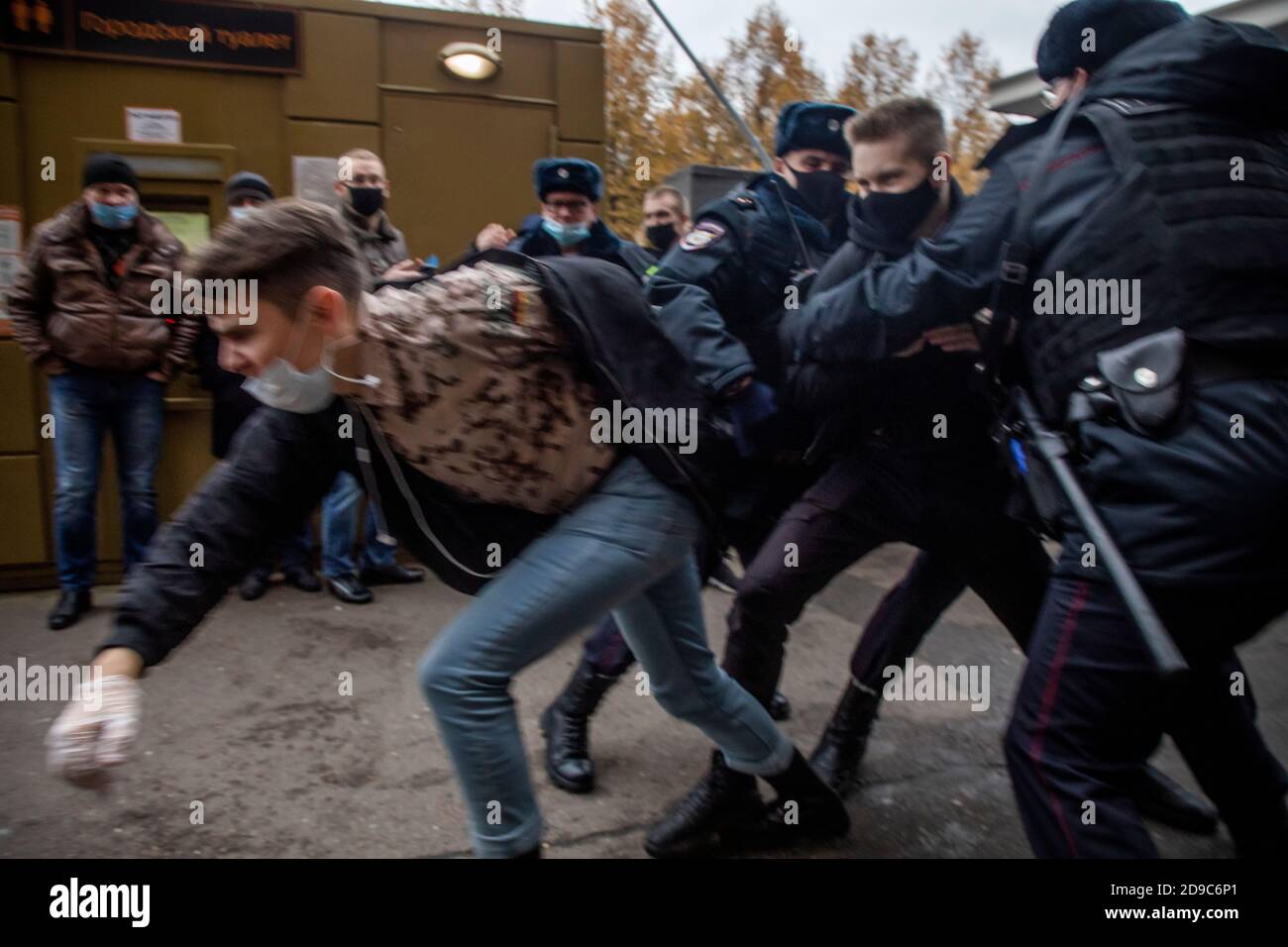 Moscow, Russia. 4th of November, 2020 Police officers detain a participant in a rally held by nationalists to mark National Unity Day near Tsvetnoi Bulvar Metro Station in the center of Moscow city, Russia. The Moscow authorities banned their traditional 'Russian March' in Moscow celebrating People's Unity Day due to the novel coronavirus COVID-19 epidemic Stock Photo