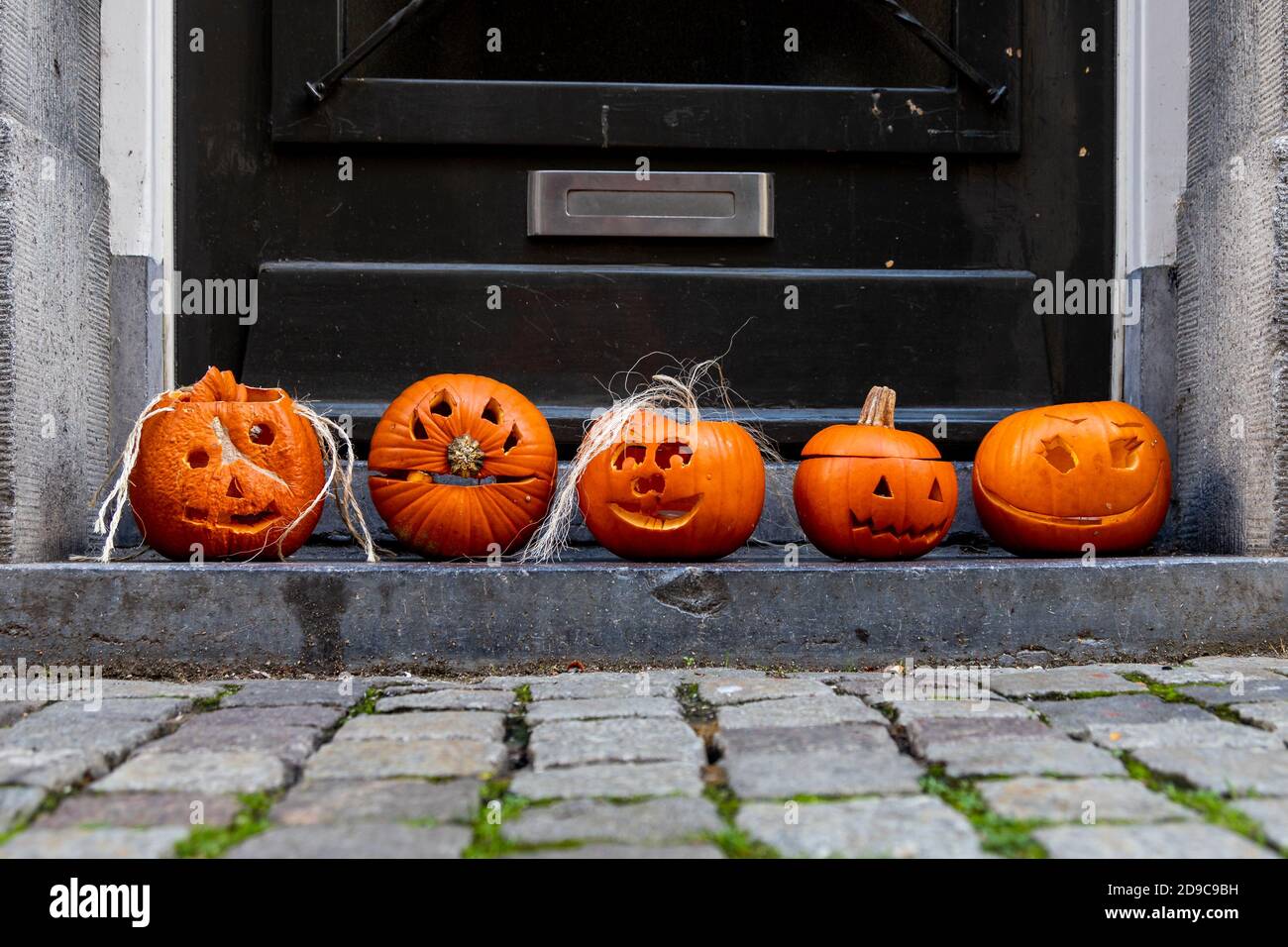 5 pumpkins at the step of a front door in Maastricht. People in Europe