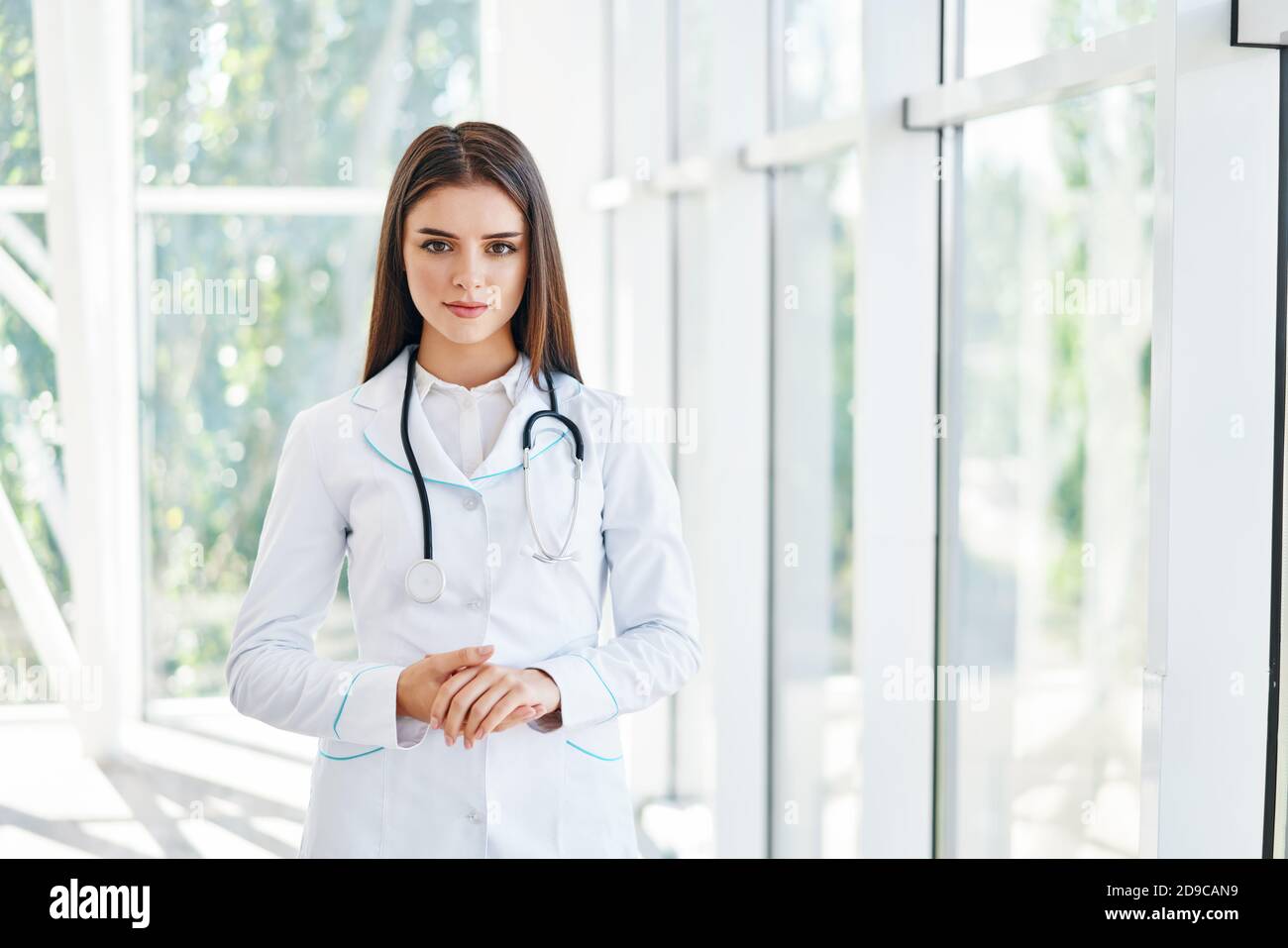 Confident doctor looking at camera in hospital background. Medicine, profession and healthcare concept Stock Photo