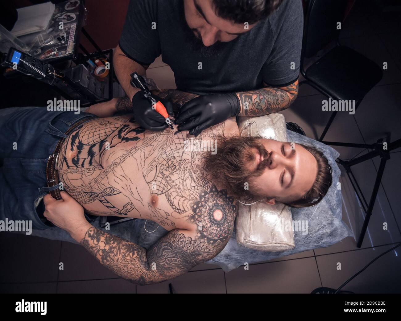 Master showing process of making a tattoo in tattoo parlour Stock Photo