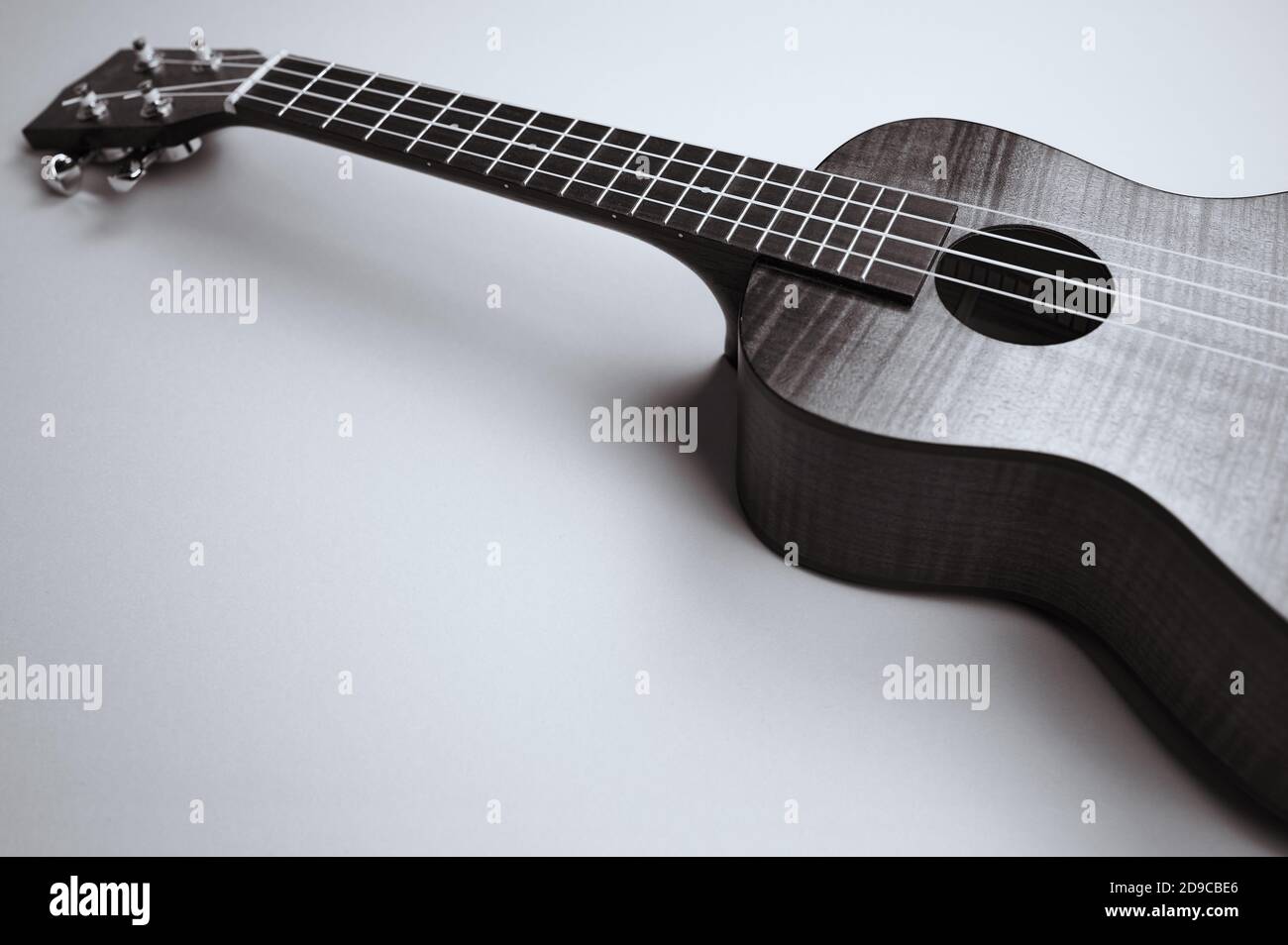 black and white photo of an ukulele on bright background with copy space Stock Photo
