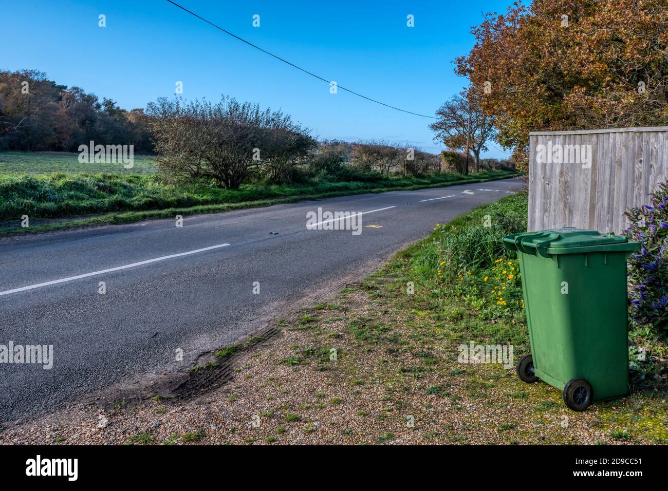 Green recycling bin outside a rural property waiting for collection. Stock Photo