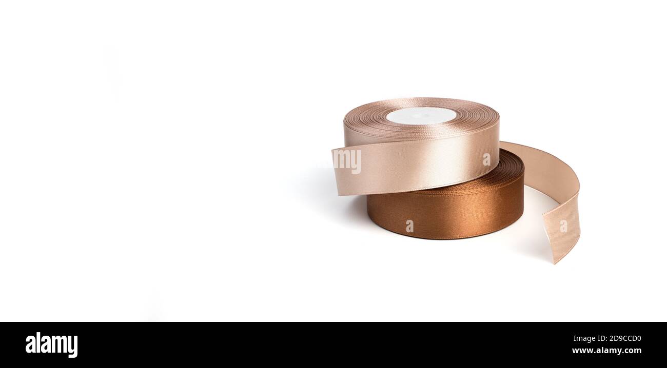Coiled Ribbons Beige and brown ribbons are rolled in a coil isolated on a white ...