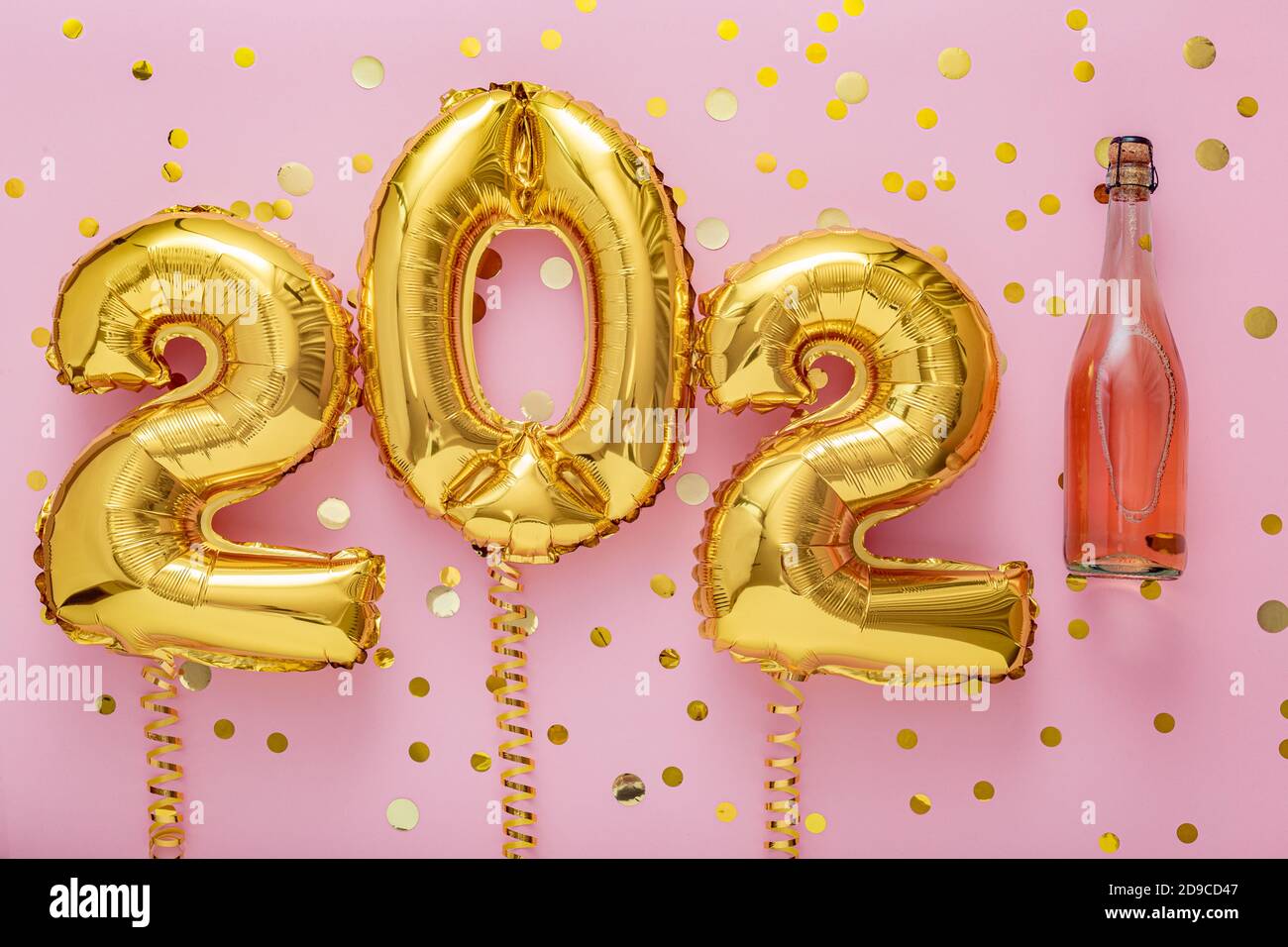 2021 golden air balloon numbers on pink background with bottle of rose champagne wine and confetti. Happy New year eve invitation card with Christmas Stock Photo