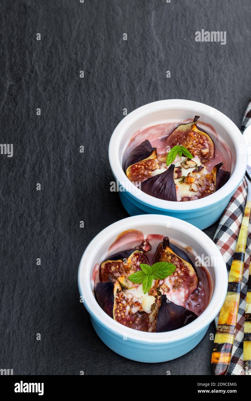 Baked fig with goat cheese and walnuts with honey on black stone