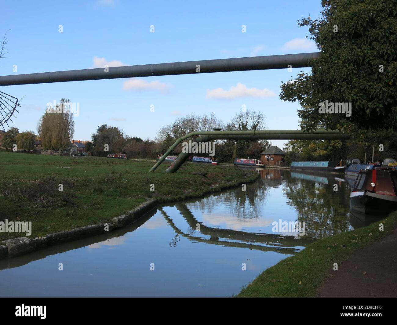 Metal pipe bridges carrying utilities across the Grand Union Canal near the village of Cosgrove, high enough to allow narrowboats to pass underneath. Stock Photo