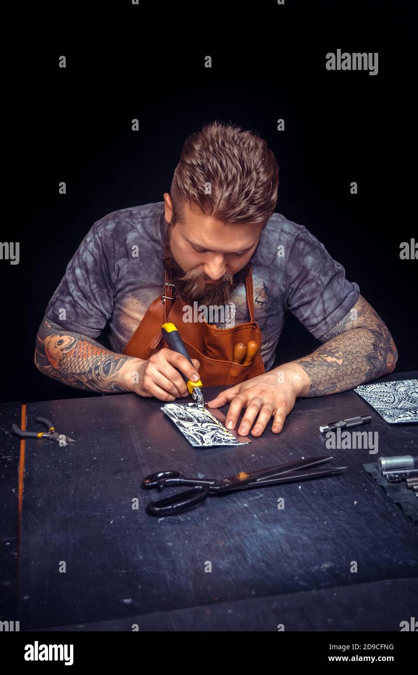 Professional Tanner creating leatherwork in his workshop Stock Photo