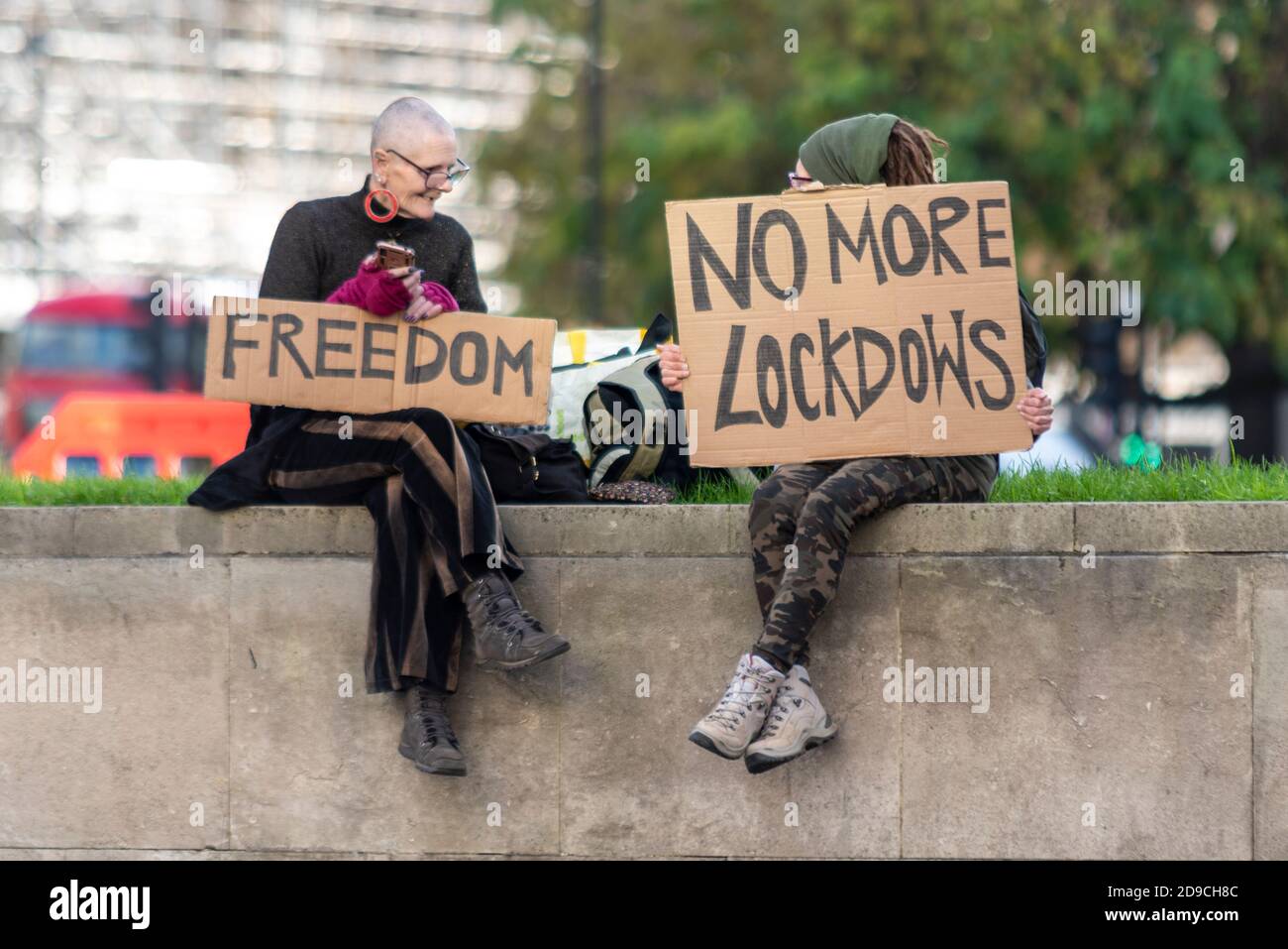 Female anti lockdown protesters with placards. Freedom. Parliament Square, Westminster, London, UK. No more lockdowns, lockdows spelling mistake Stock Photo