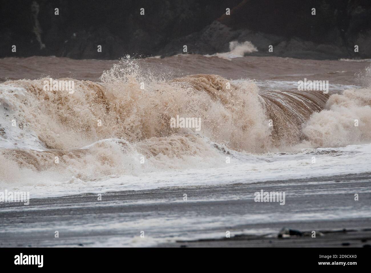 A large wave breaking on a beach durine a gale. Lots of spay and detail visible. Stock Photo