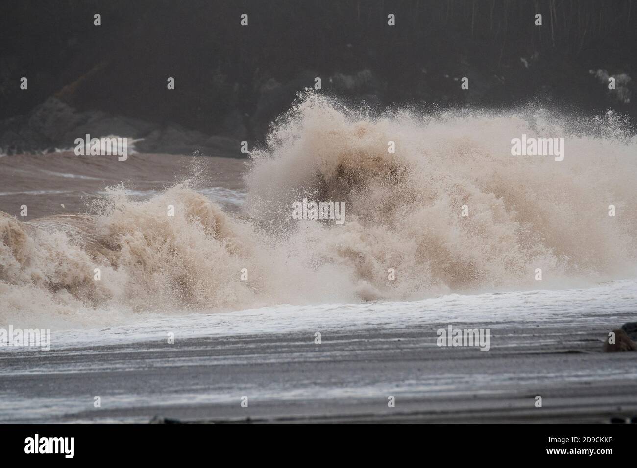 A large wave breaking on a beach durine a gale. Lots of spay and detail visible. Stock Photo