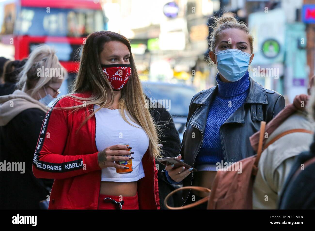 Shoppers wearing face masks queuing outside a departmental store in London as all non-essential retailers will close from midnight tonight, for a month.This follows the announcement by the Prime Minister, Boris Johnson, of the second national lockdown in England from Thursday 5 November until Wednesday 2 December, to control the increase of coronavirus cases. Stock Photo