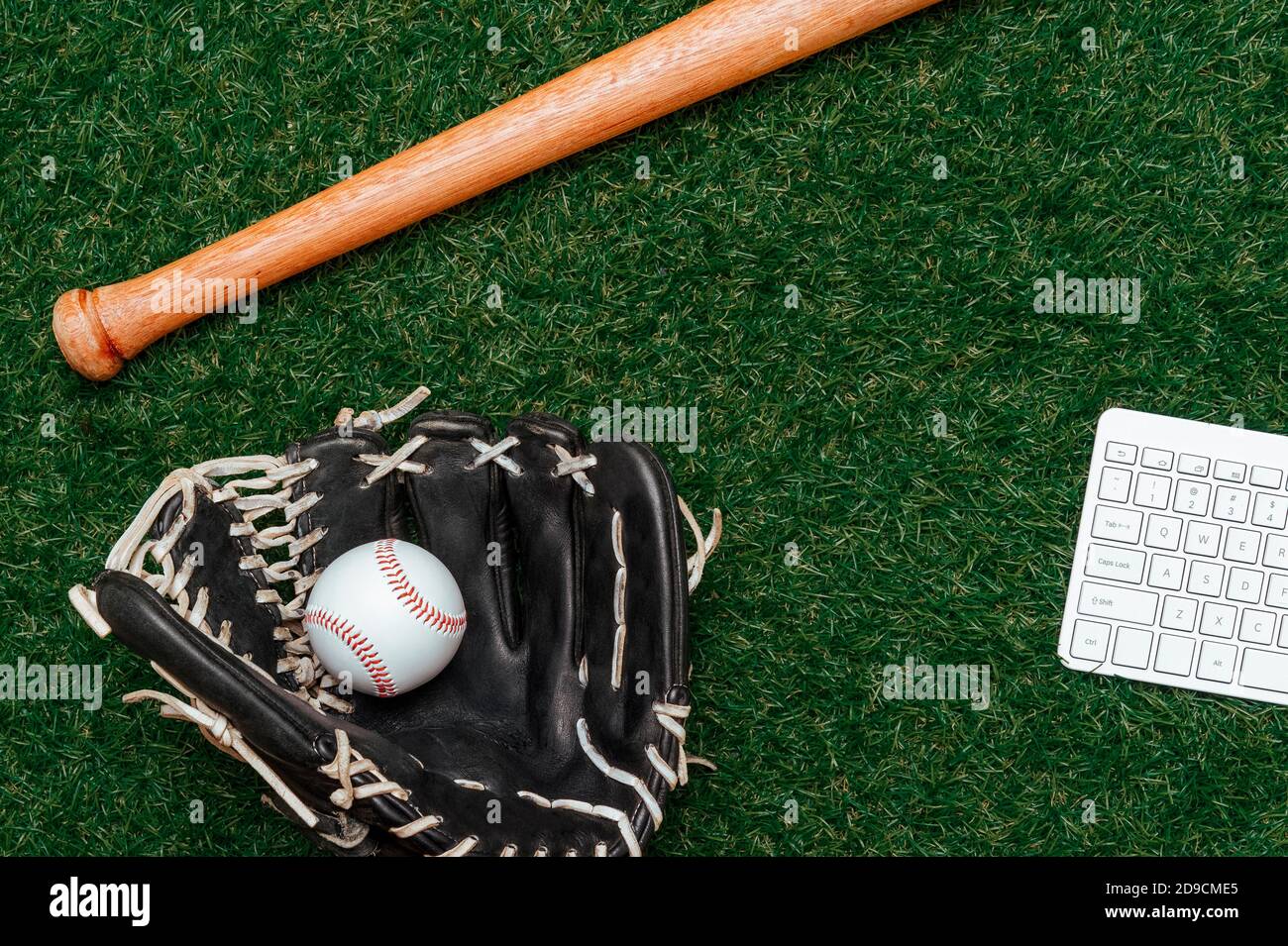 Baseball bat, ball, glove and computer keyboard isolated on a field of ...