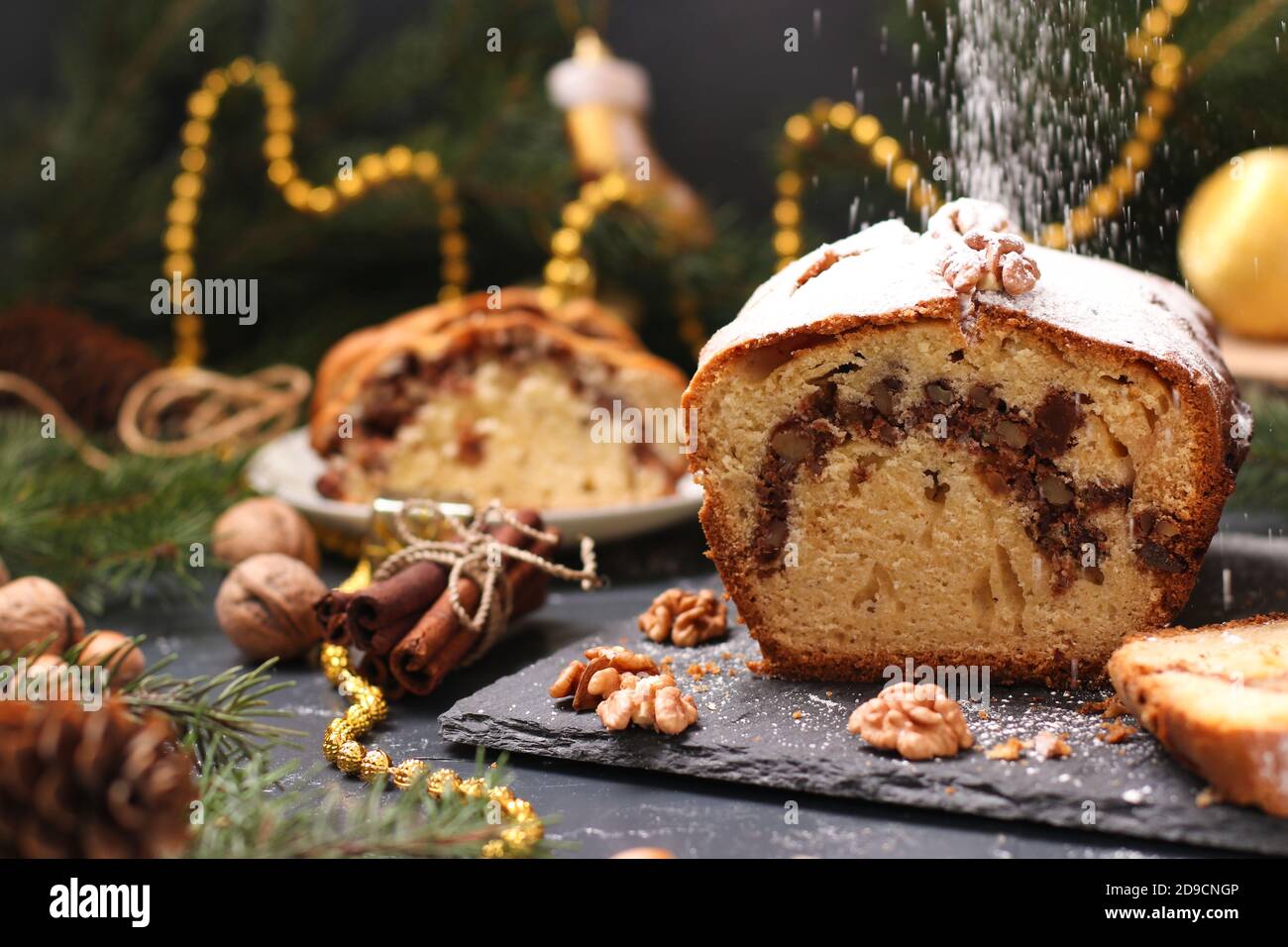Christmas cupcake with nuts and candied, covered with icing sugar located on the Christmas background Stock Photo