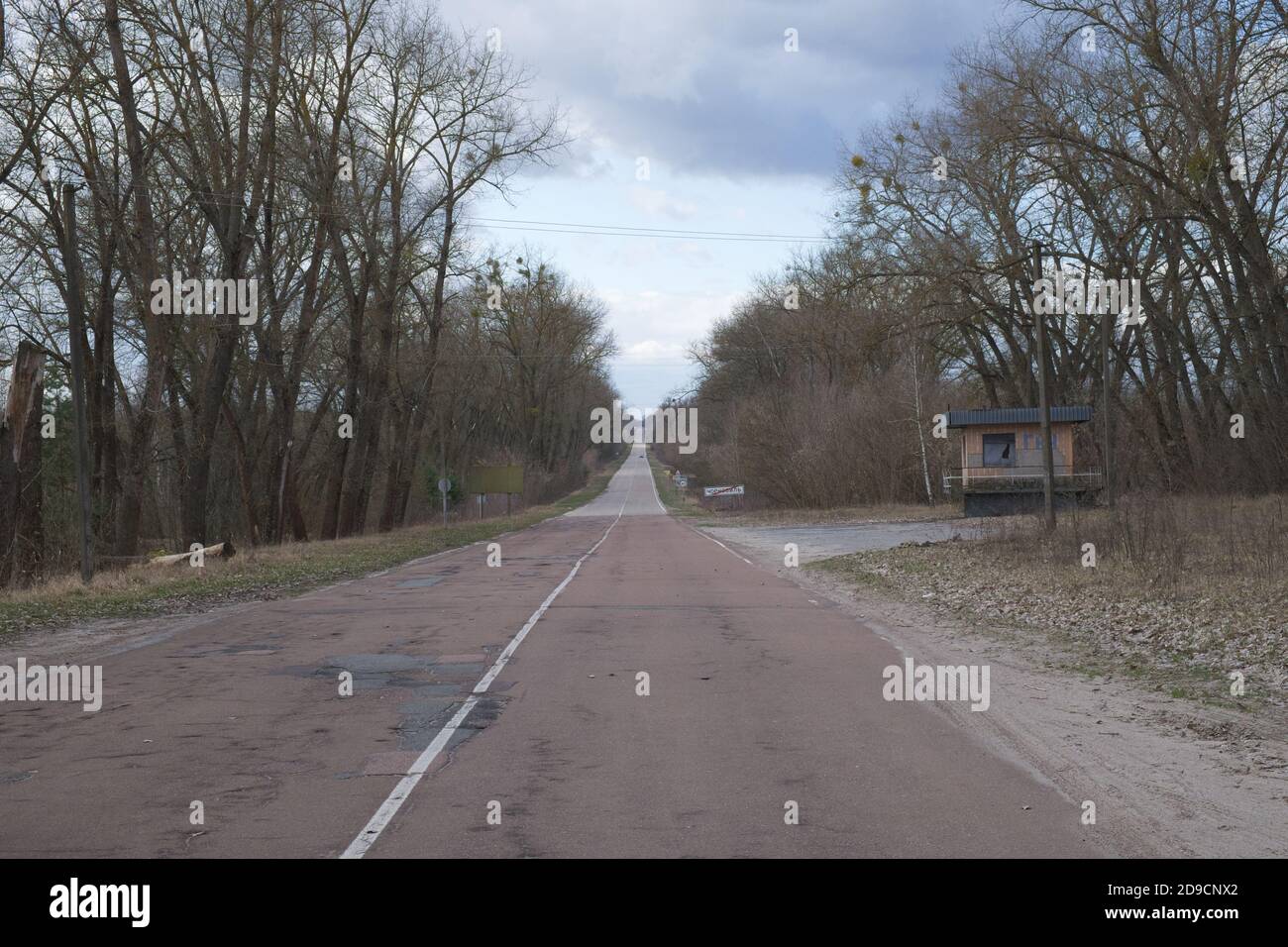 Long straight road to the Chernobyl radioactive exclusion zone. Stock Photo