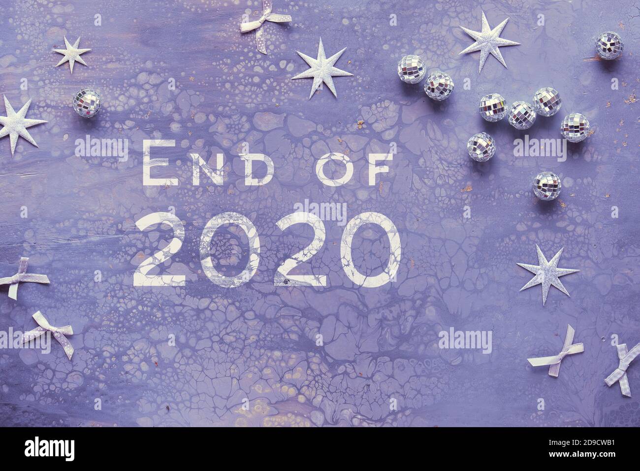 Text End of 2020. Flat lay on acrylic painted board with mirror balls ...