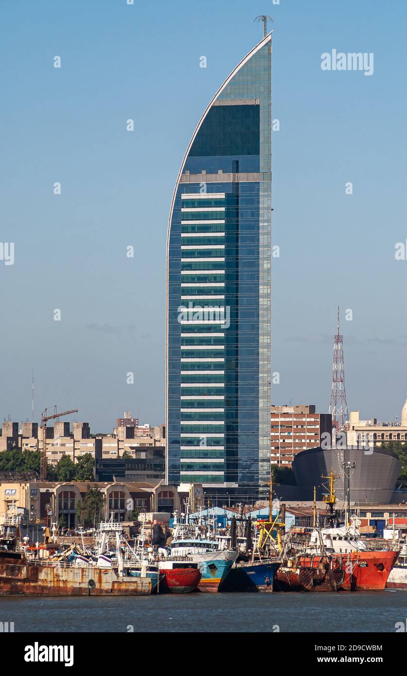 Montevideo, Uruguay- December 18, 2008: Port with fishing vessels in front of Blue and silver Joaquin Torres Garcia Tower of ANTEL telecommuniations a Stock Photo