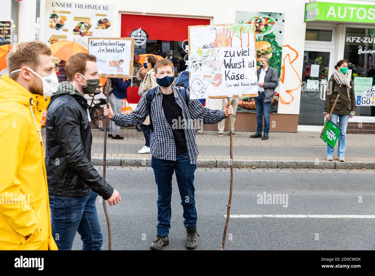 Gottingen, Germany. Autumn 2020. Fridays for future. Young caucasian man holding up picket signs on street during protest. Full length. Stock Photo