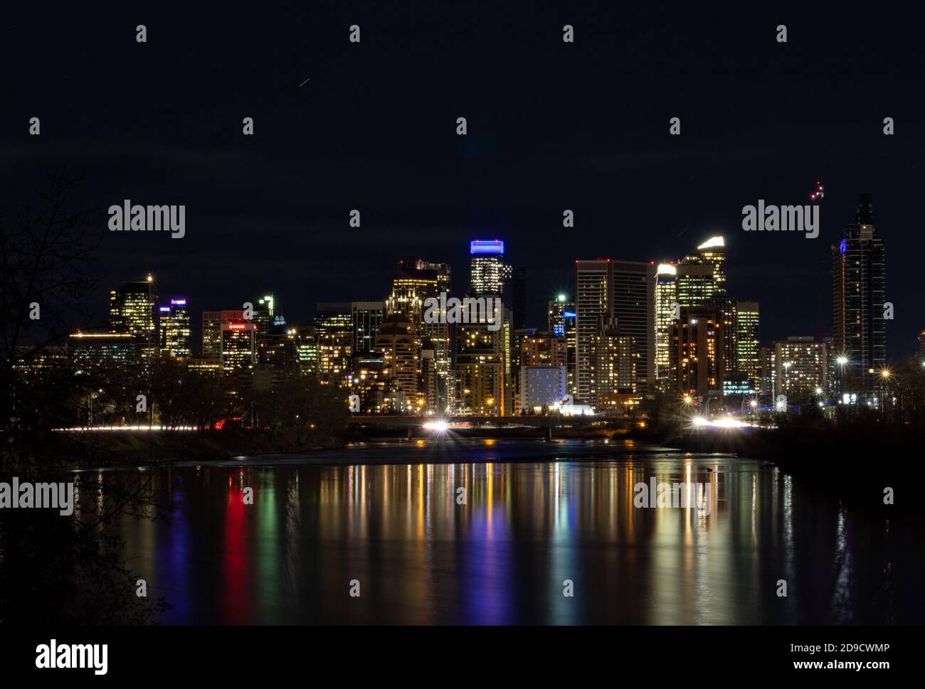 Calgary Alberta skyline from the west at night reflected in the Bow River Stock Photo