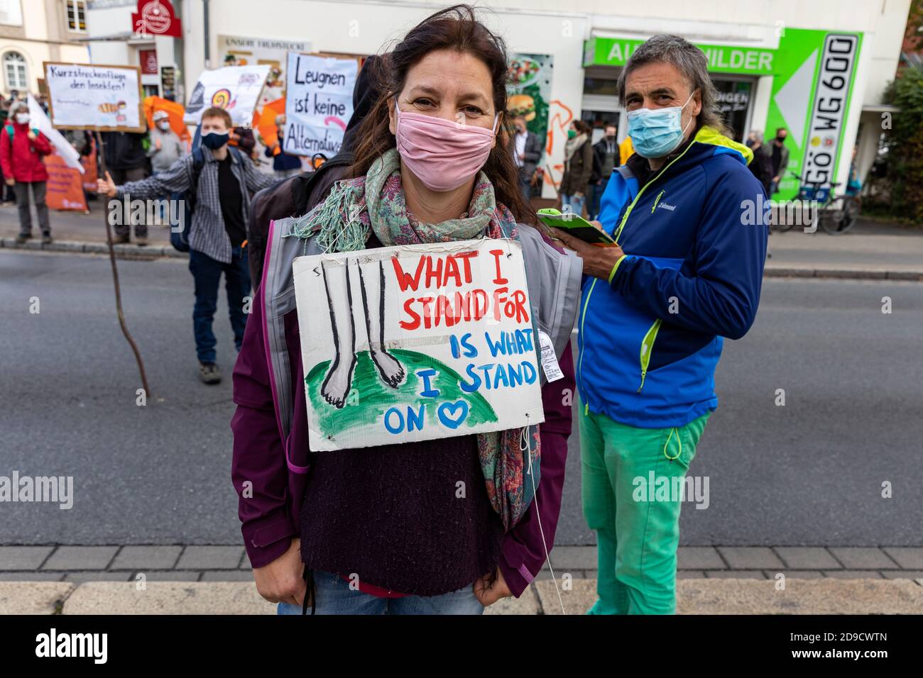 Gottingen, Germany. Autumn 2020. Fridays for future. Protester against climate change posing for camera with sign on neck. Front view. Medium shot. Stock Photo