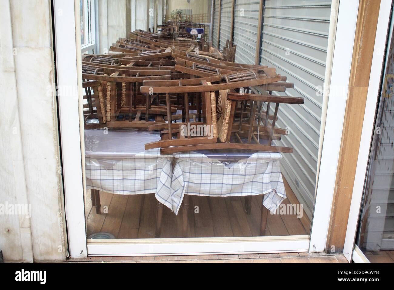 Greece, Athens, November 3 2020 Chairs, tables and other furniture stacked outside closed cafe