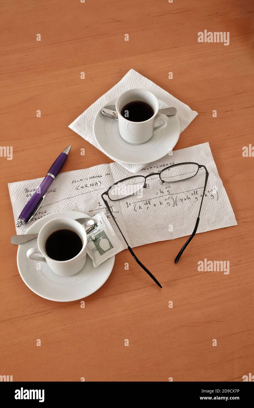 Coffee cups, spectacles, pen and biological calculation Stock Photo
